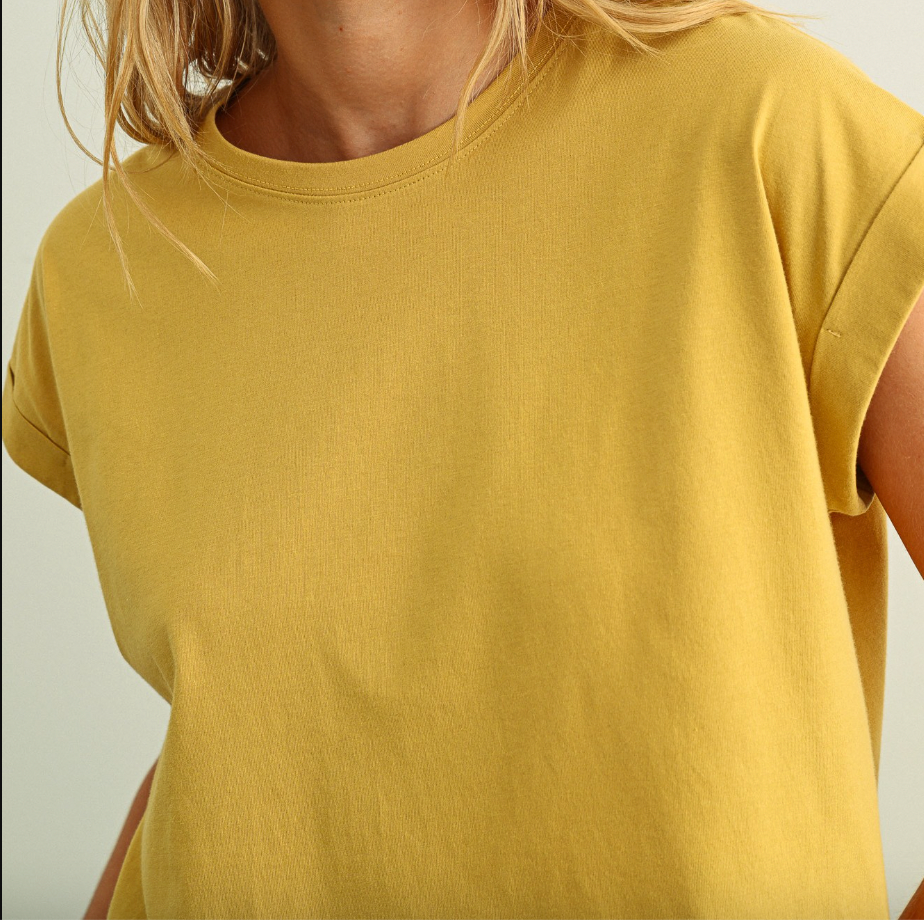 Yellow t-shirt worn by a person on a light gray background
