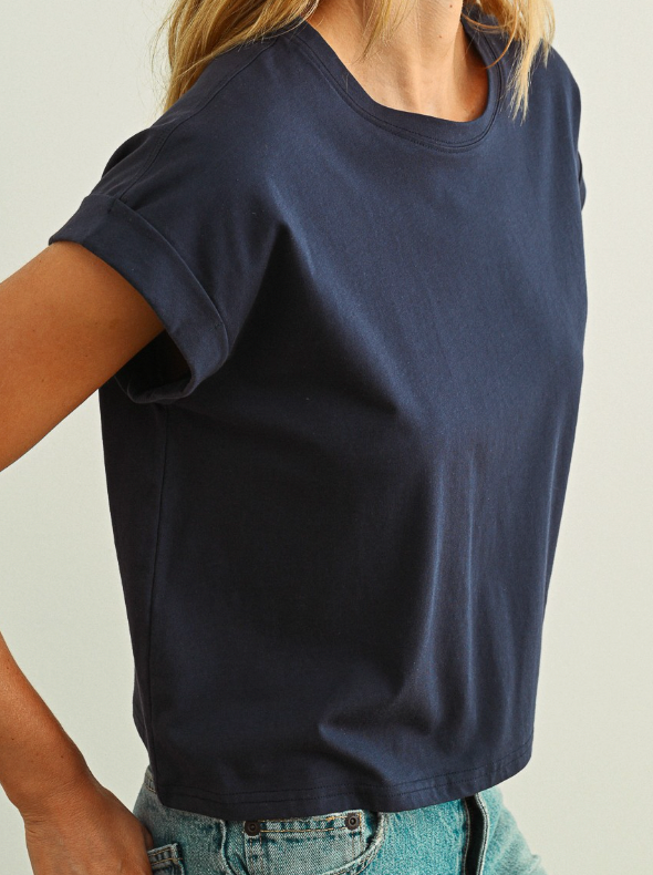 Person wearing a navy blue t-shirt against a neutral background