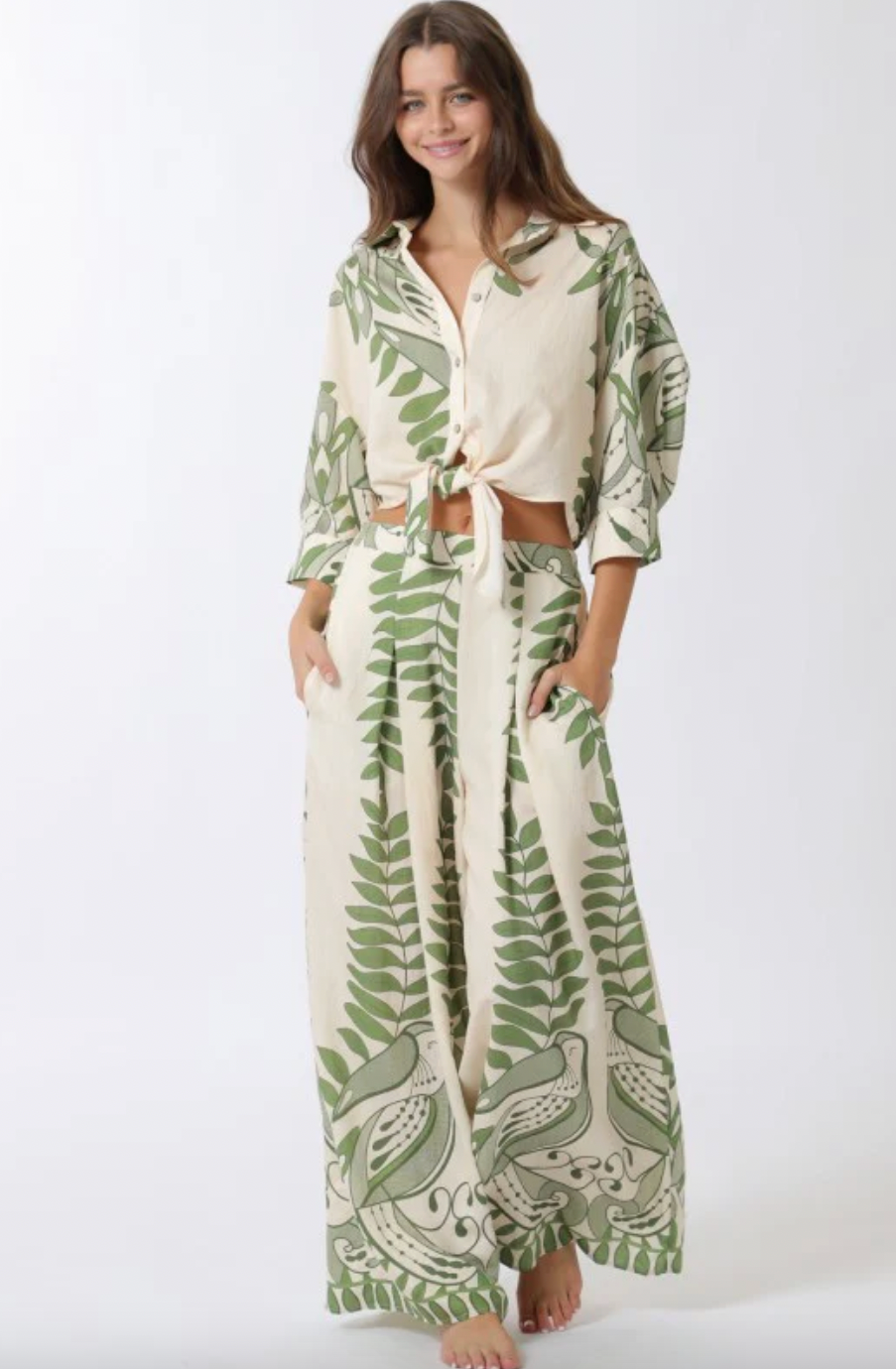 Woman wearing a green and white patterned outfit on a white background