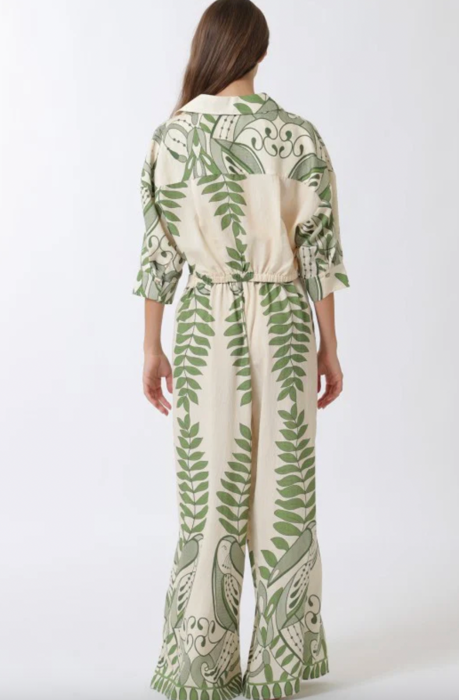 Person wearing a green and white patterned outfit on a white background