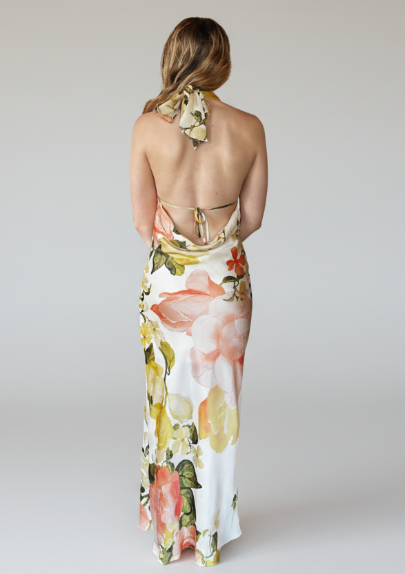 Woman wearing a floral halter neck dress on a white background