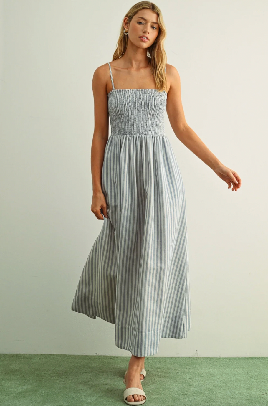 Woman wearing a striped dress against a plain background