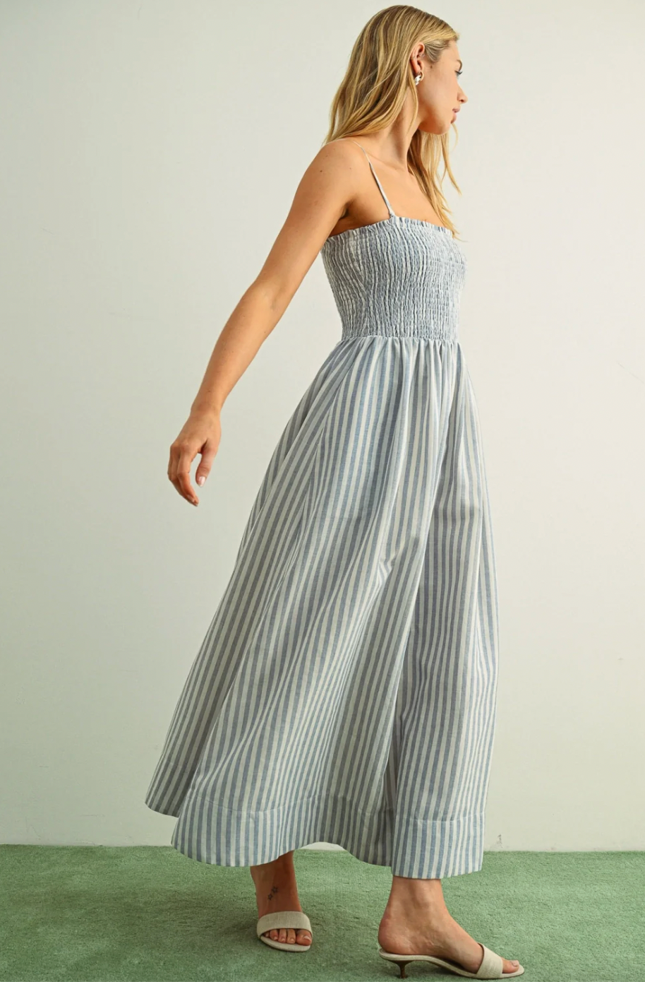 Woman wearing a striped dress on a plain background