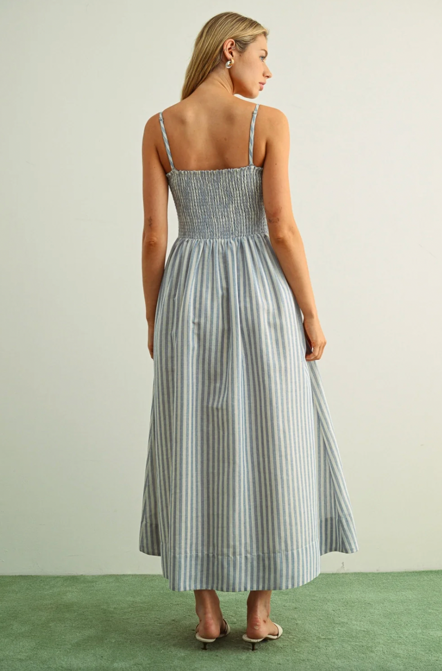 Woman wearing a striped dress with a neutral background