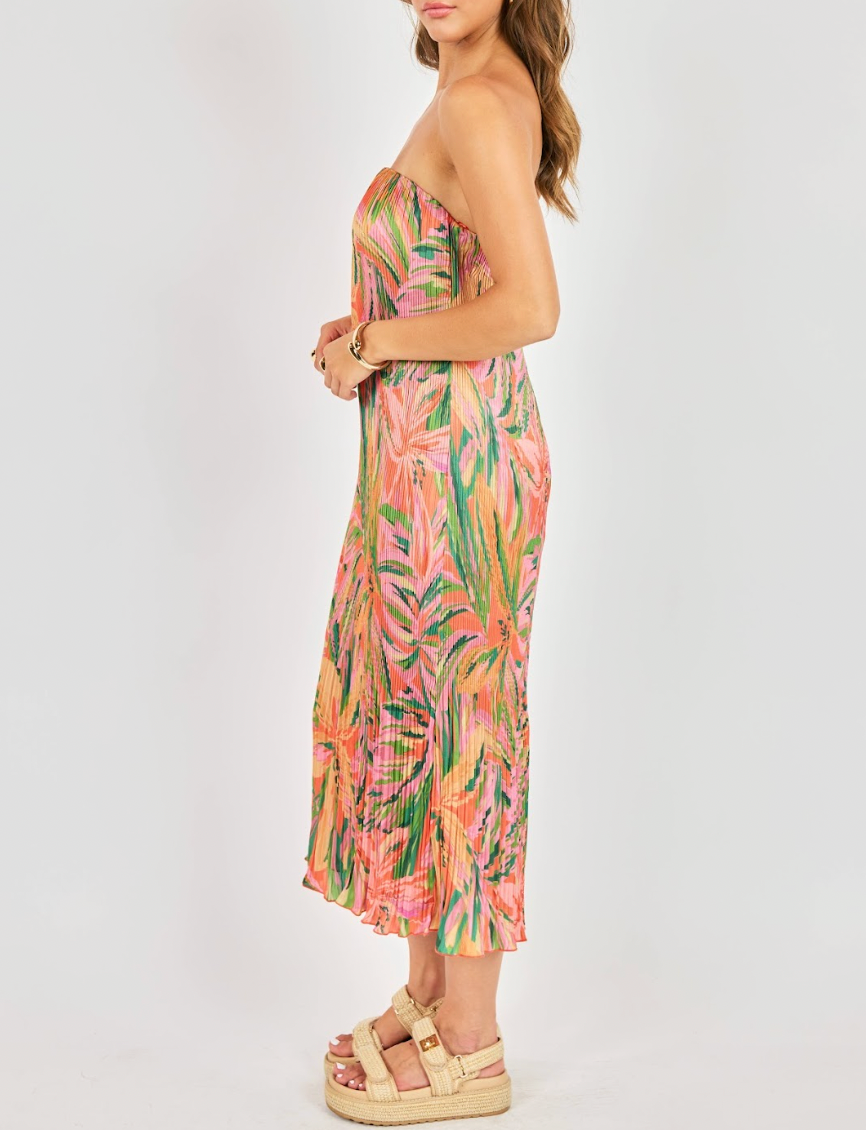 Woman wearing a strapless dress with a tropical leaf pattern on a white background