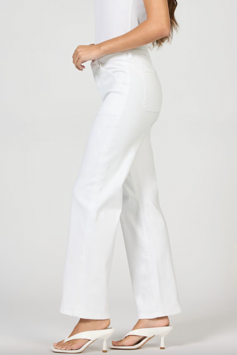 White pants worn by a person on a plain background