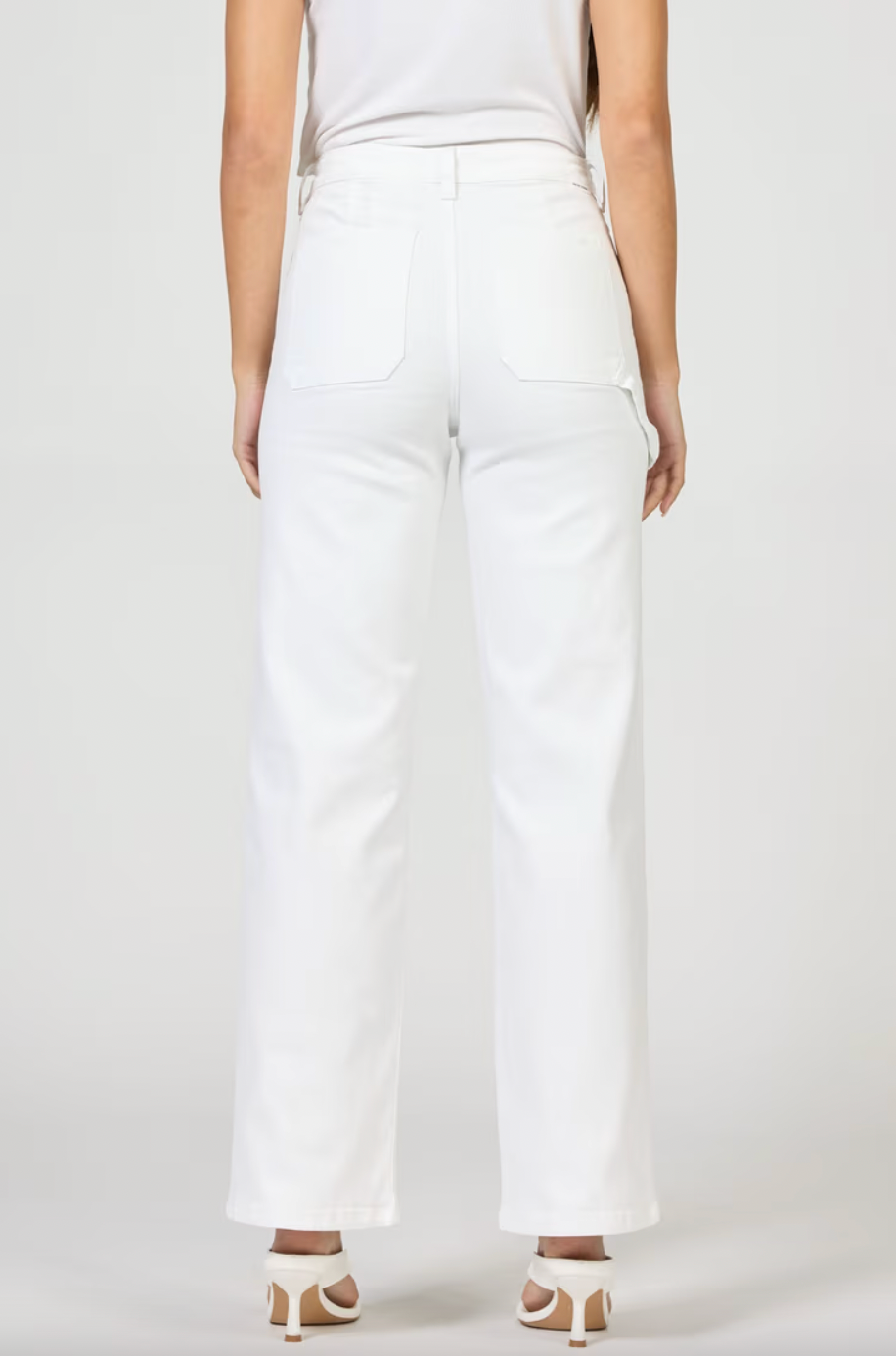 Person wearing white pants on a plain background
