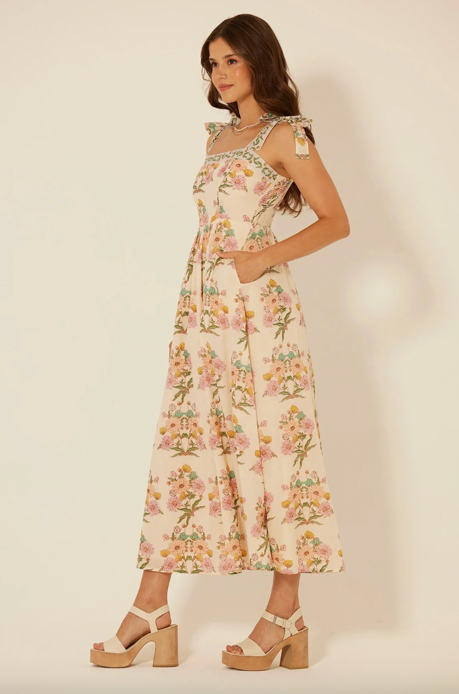 Woman wearing a floral dress on a plain background