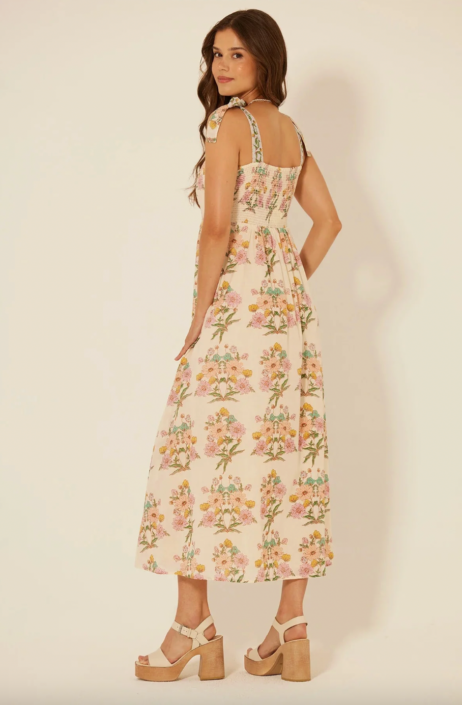 Woman wearing a floral dress on a plain background