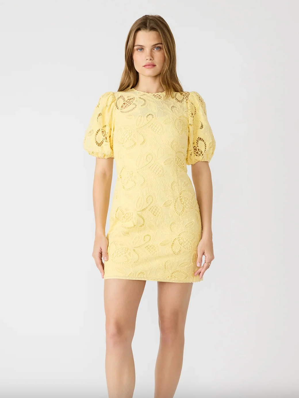 Woman wearing a yellow lace dress on a white background