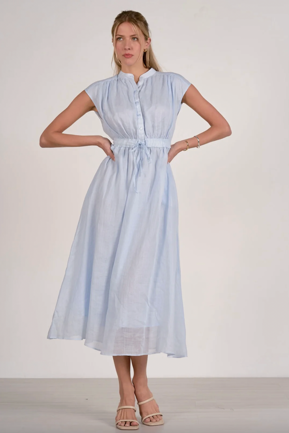 Woman wearing a light blue dress against a white background