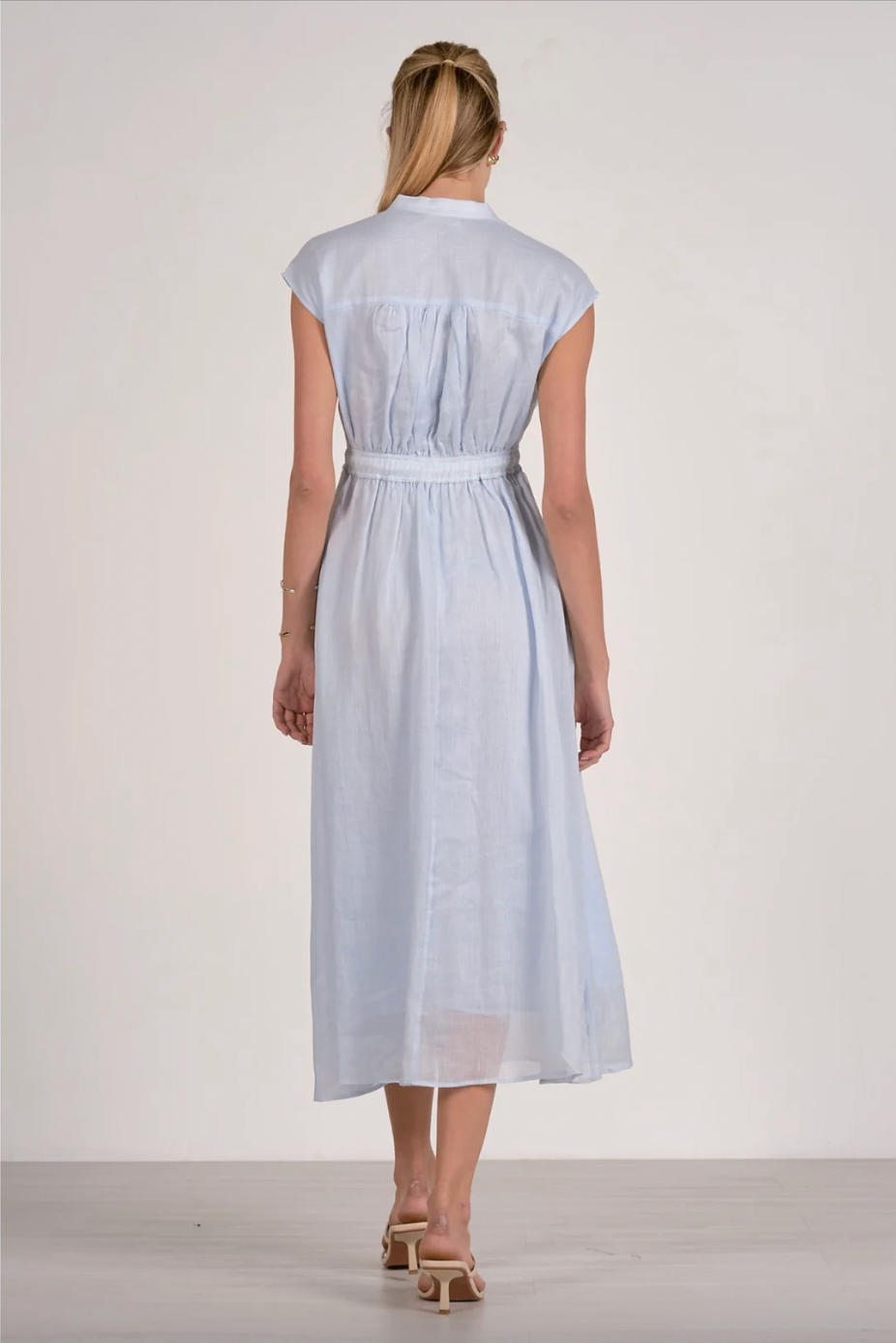 Woman wearing a light blue dress with a white background