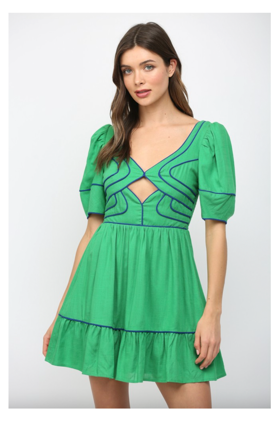 Woman wearing a green dress with blue accents on a white background