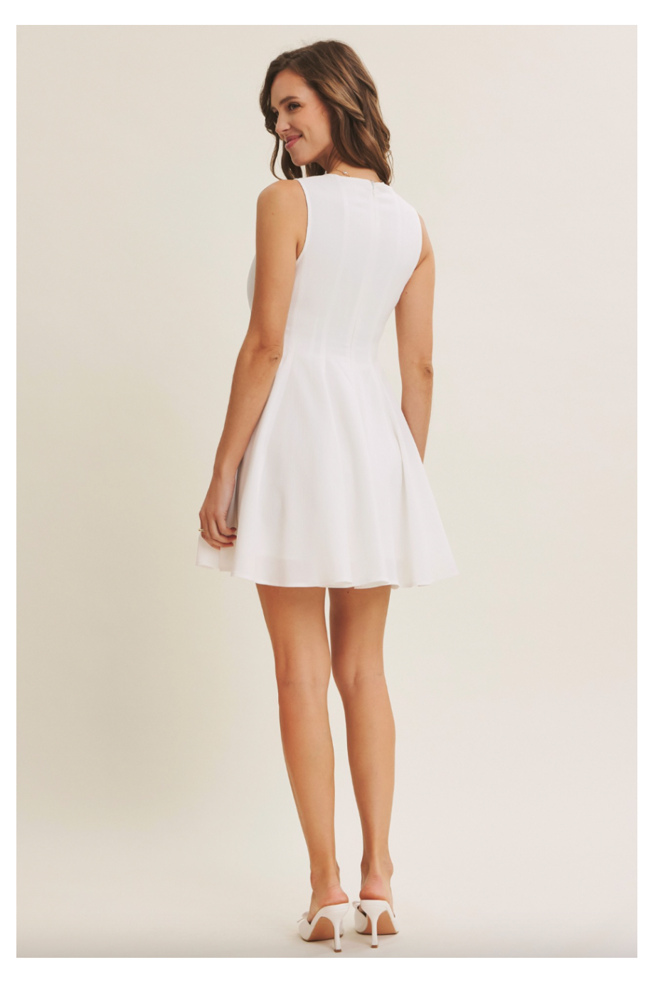 Woman wearing a white dress against a plain background