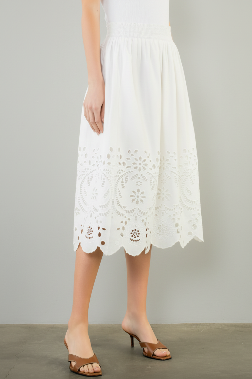 White lace skirt worn by a person on a plain background