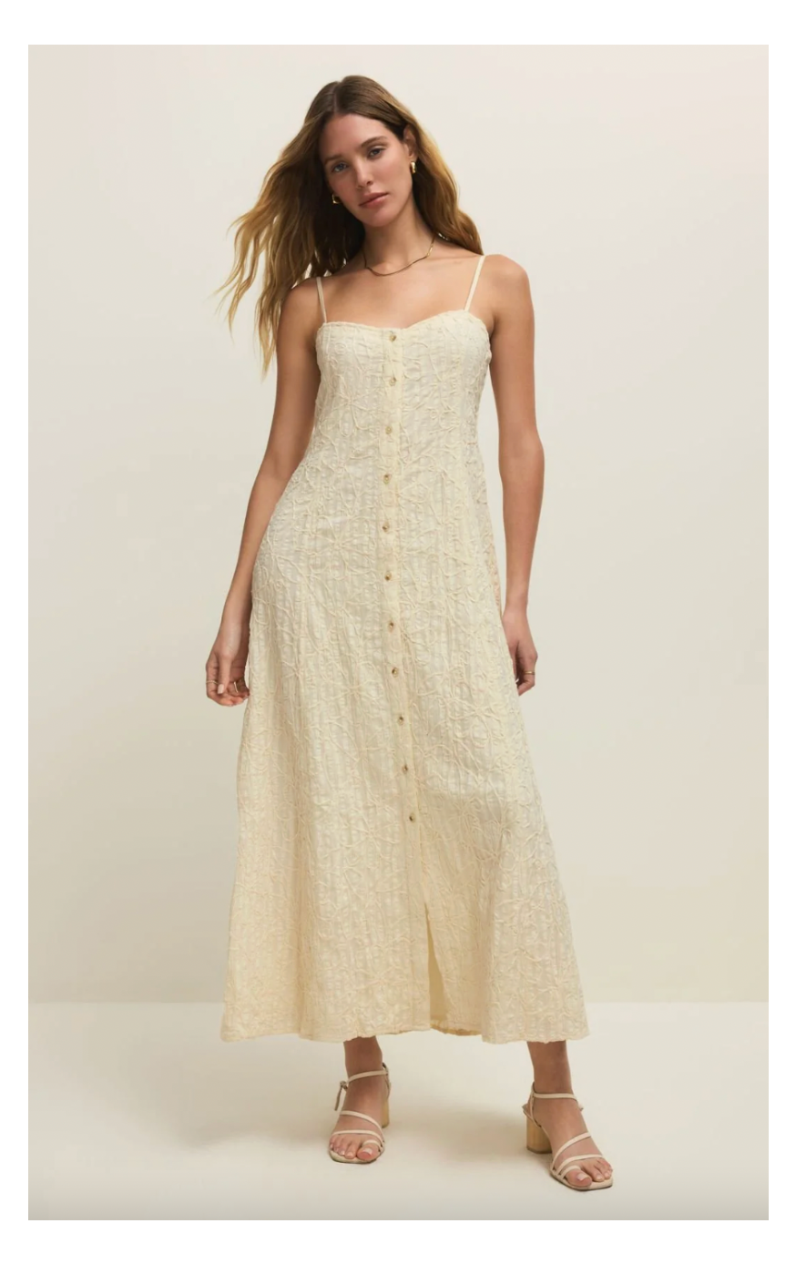 Woman wearing a beige dress with buttons on a white background