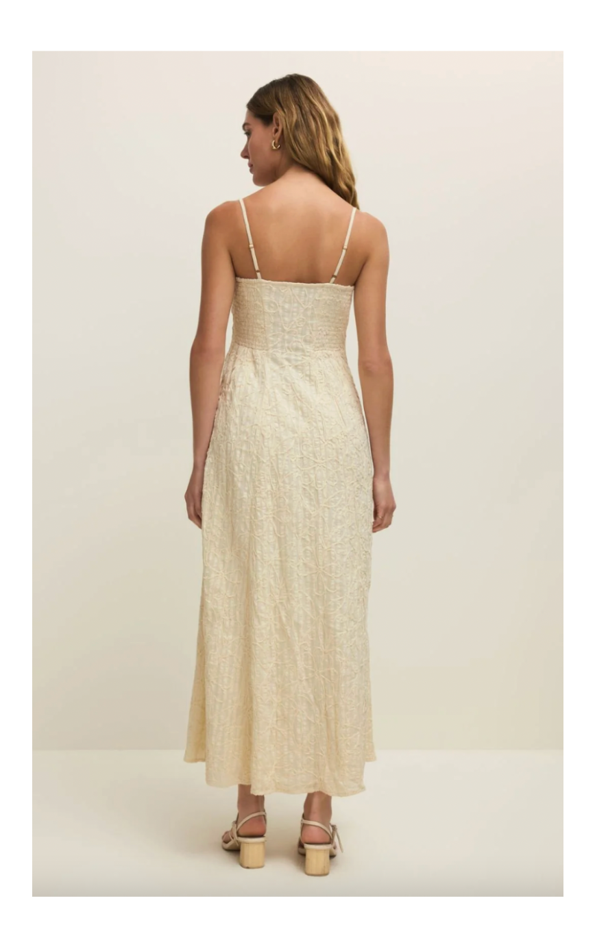 Woman wearing a beige dress with thin straps on a white background