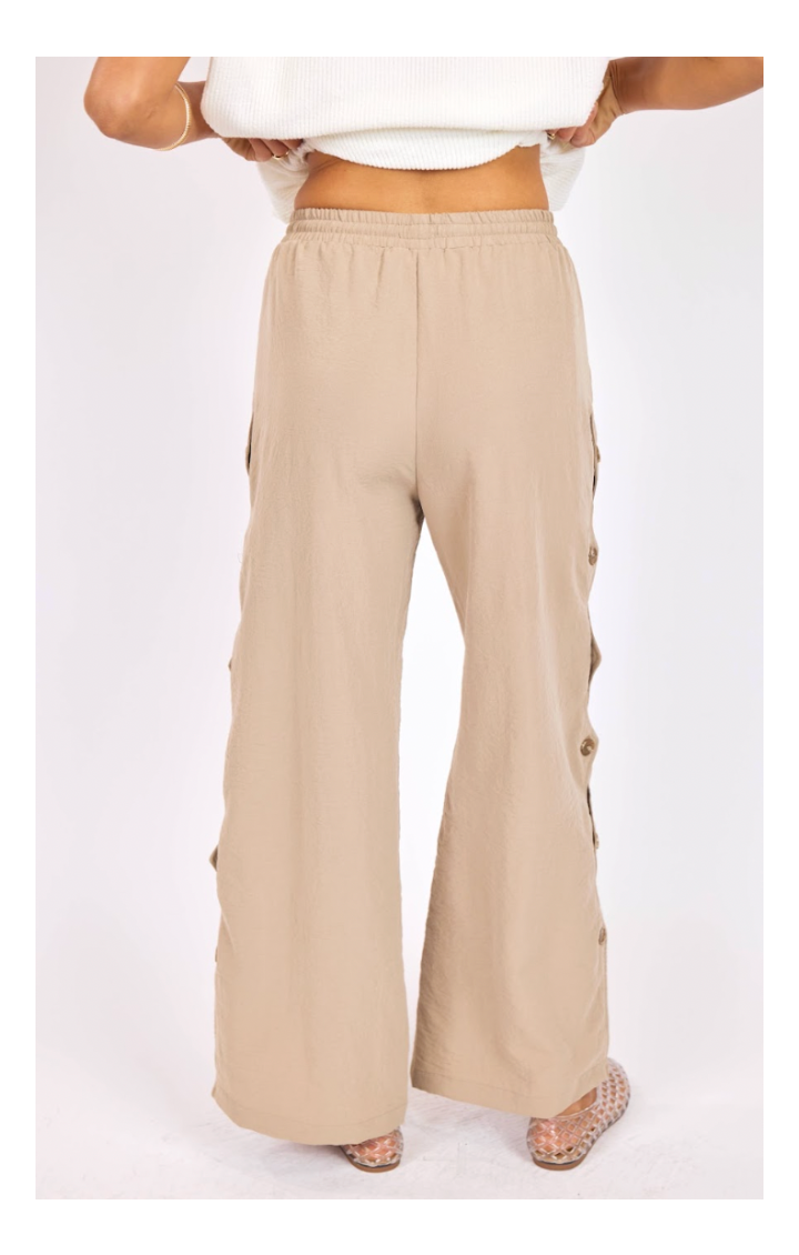 Beige wide-leg pants with button details on a white background