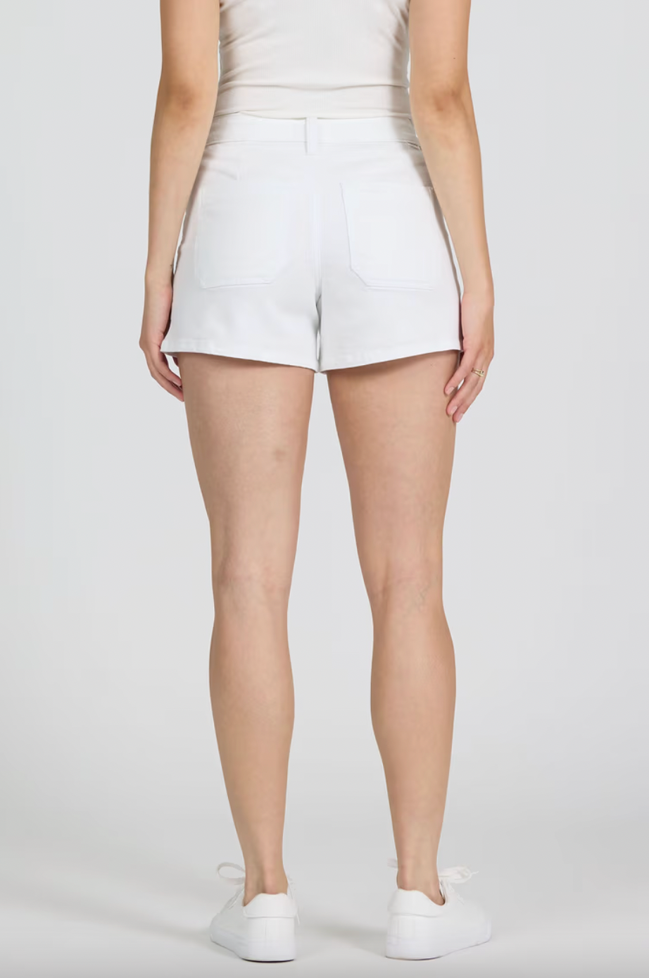 Person wearing white shorts on a plain background