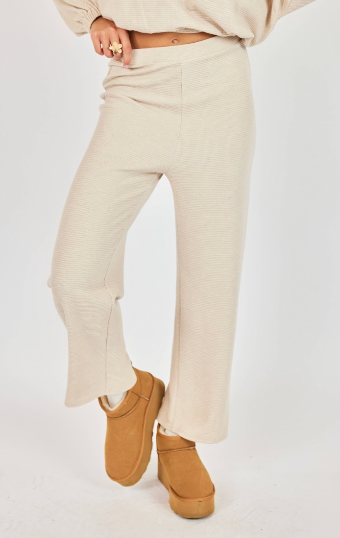 Person wearing a beige outfit with platform boots on a white background