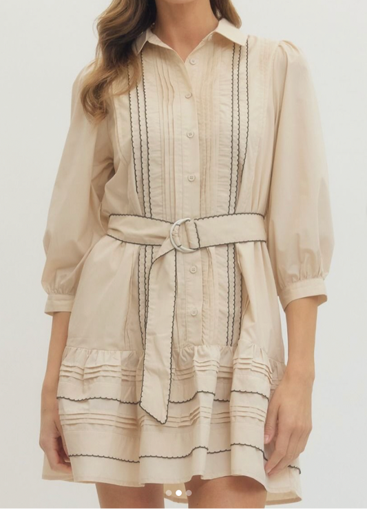 Woman wearing a beige dress with black stripes on a white background