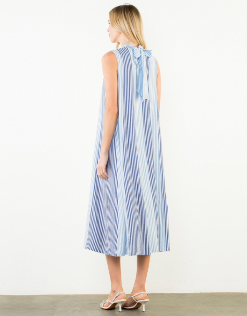 Woman wearing a blue and white striped dress on a plain background