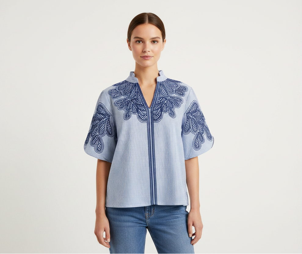 Blue and white striped blouse with intricate embroidery on a mannequin against a white background