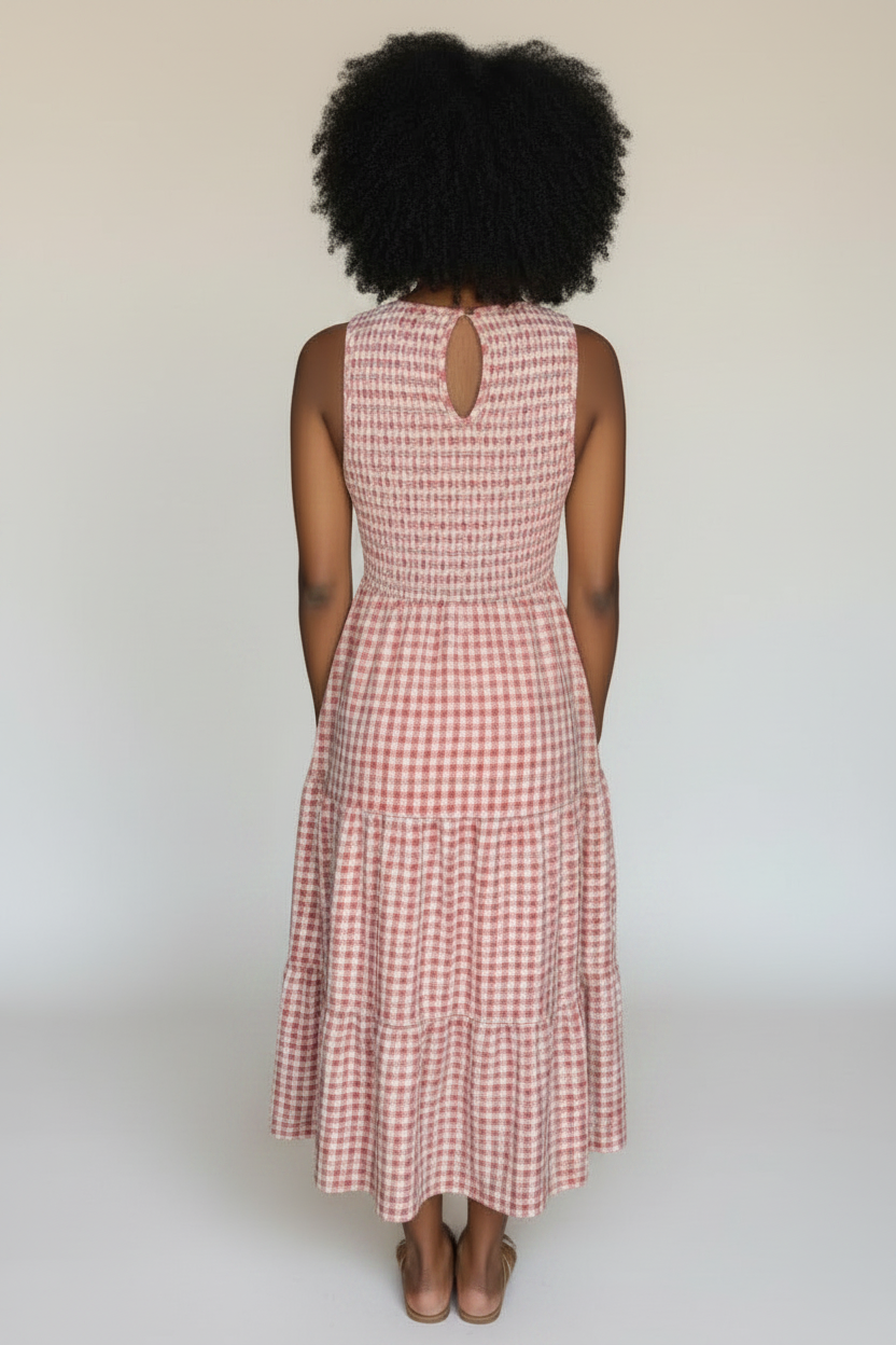 Woman in a red checkered dress standing in a store with clothing and accessories on display.