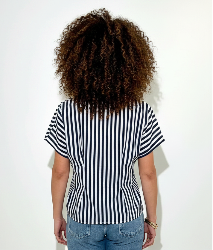 Person wearing a black and white striped shirt against a white background