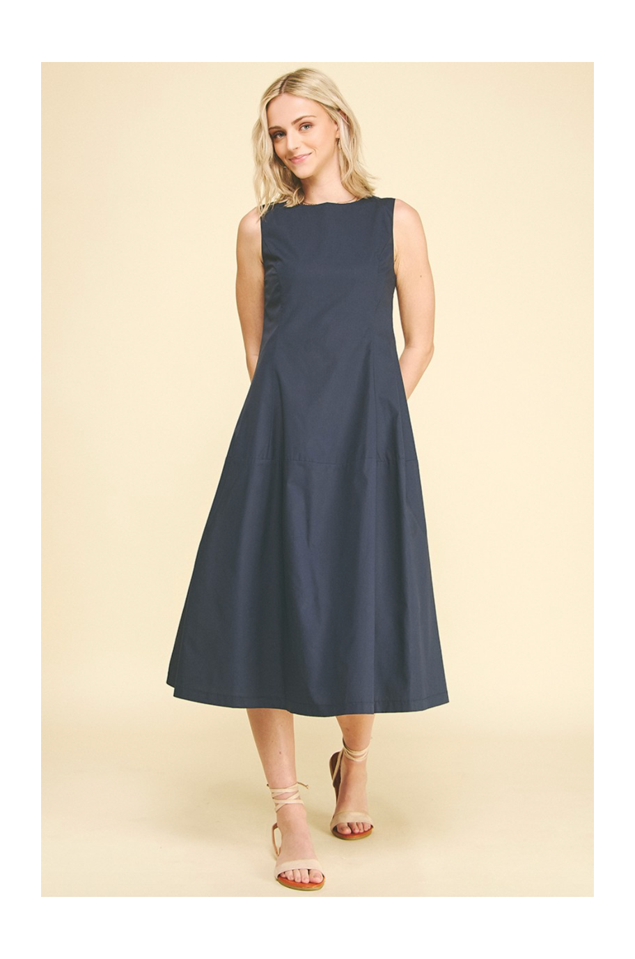 Woman wearing a navy blue dress on a beige background