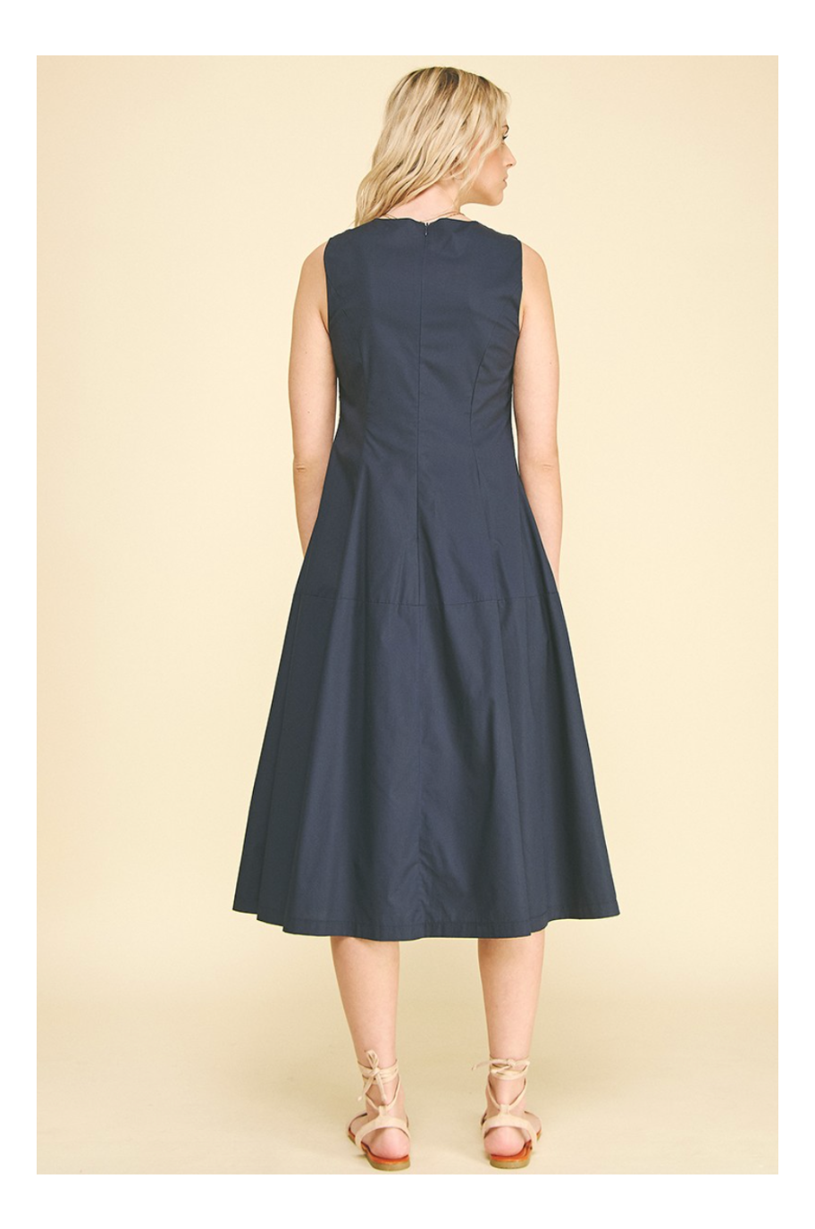 Woman wearing a navy dress on a beige background