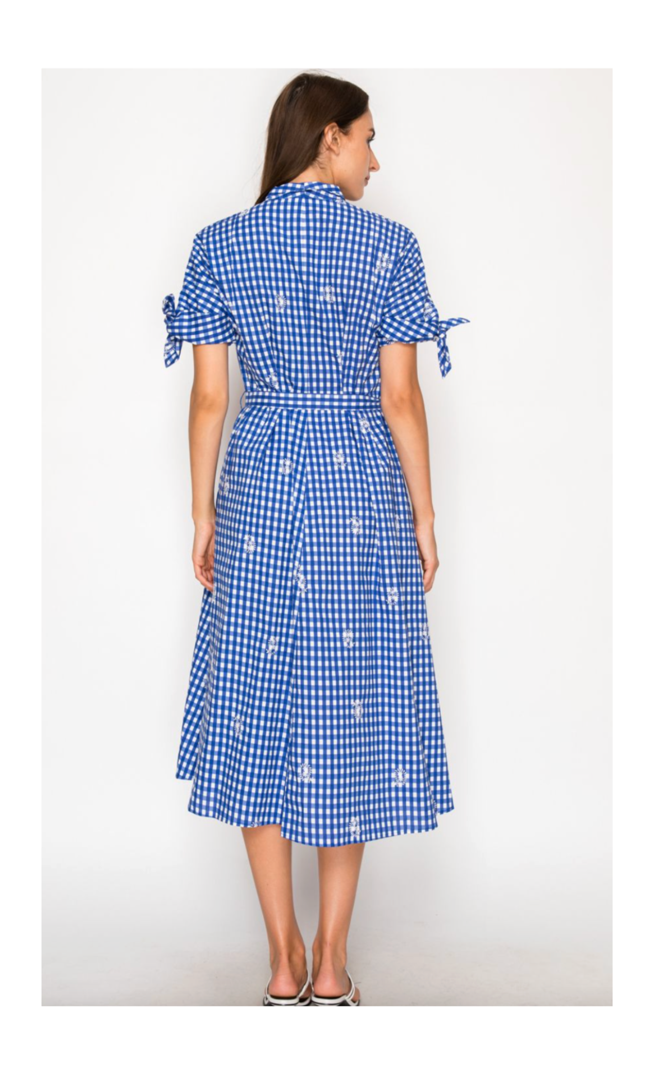 Woman wearing a blue checkered dress on a white background