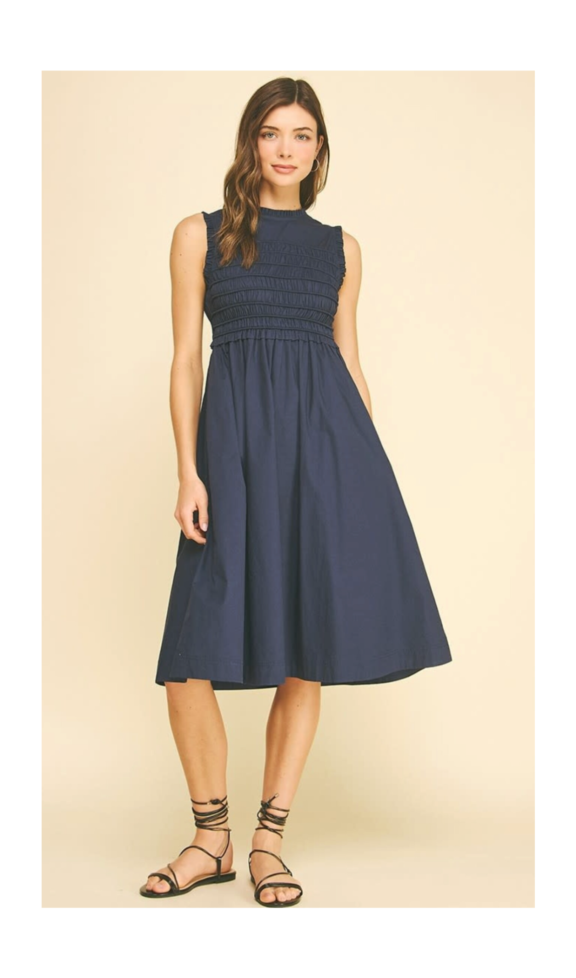 Woman wearing a navy blue dress on a beige background