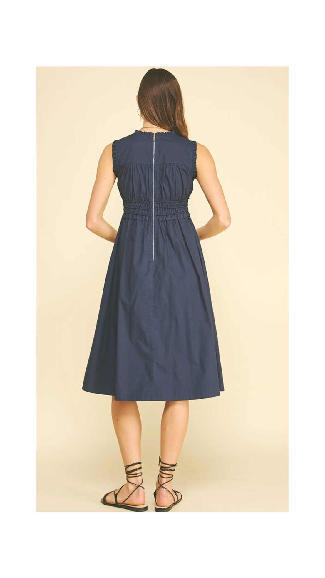 Navy blue sleeveless dress worn by a model on a beige background