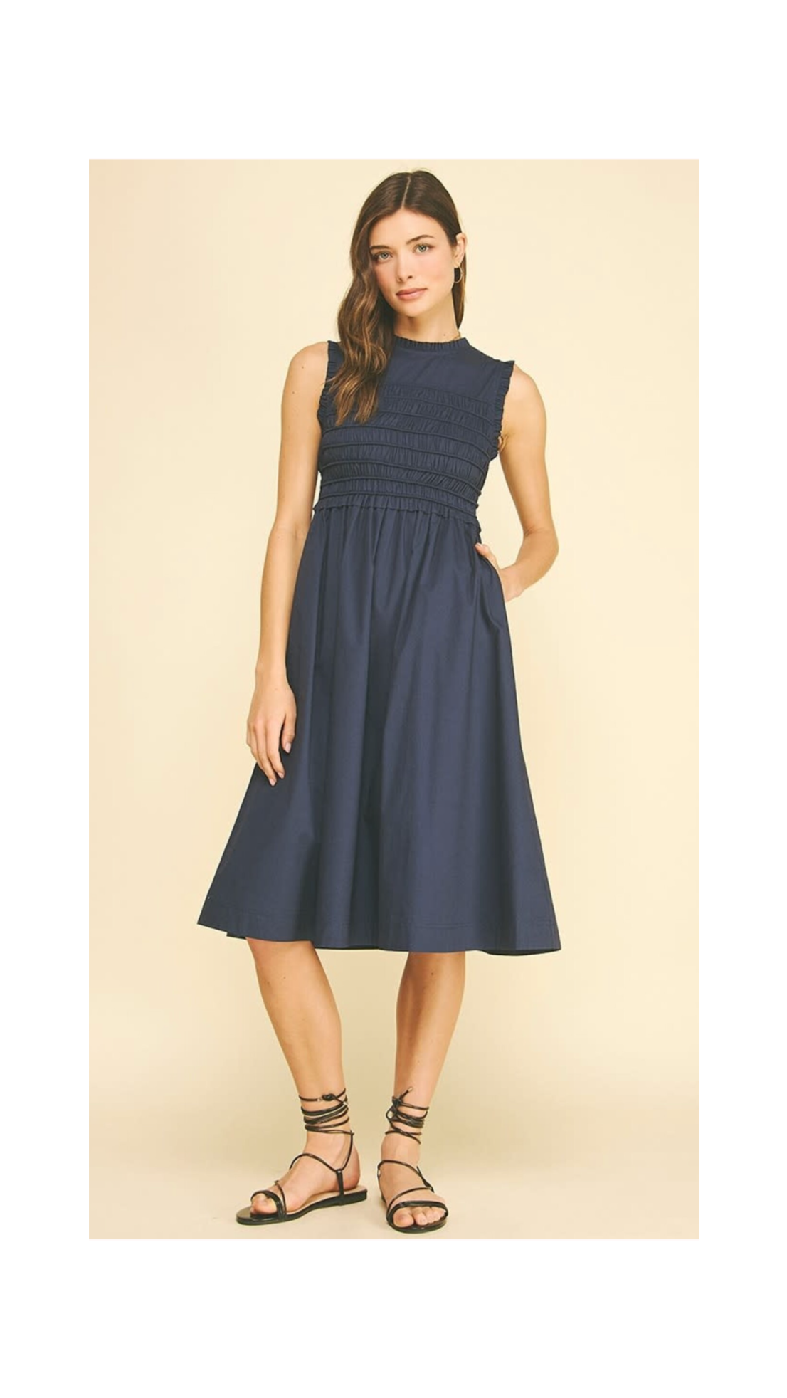 Woman wearing a navy blue dress on a beige background