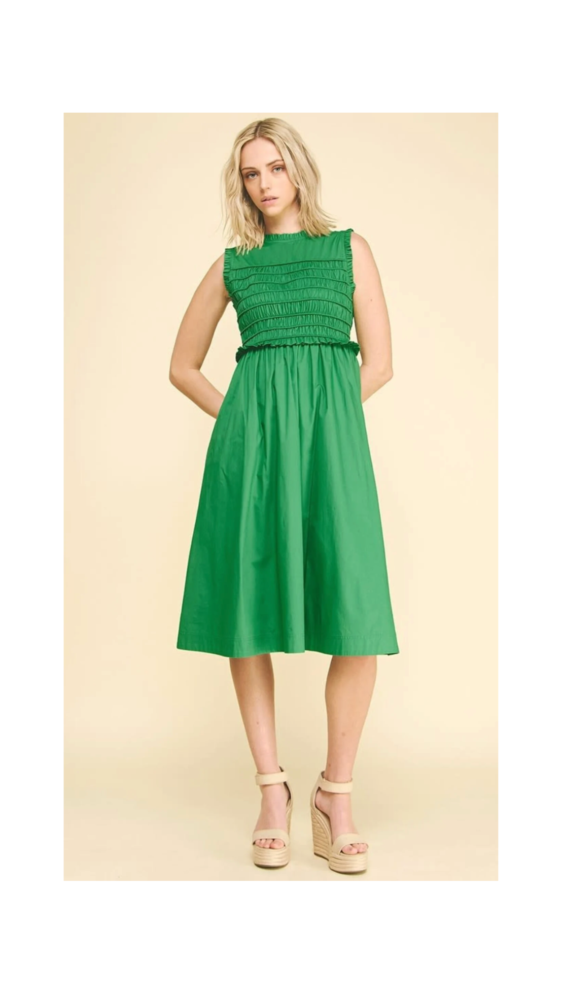 Woman wearing a green dress on a beige background