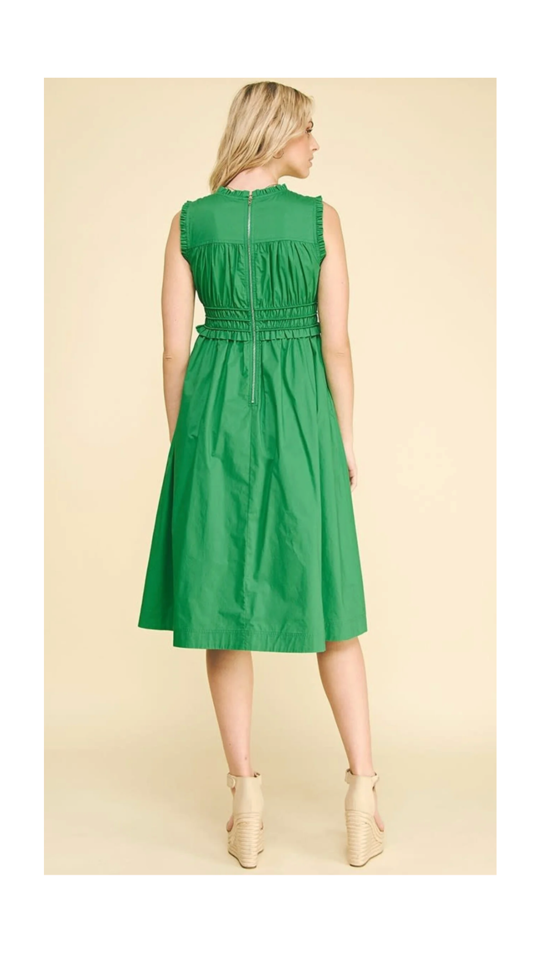 Woman wearing a green dress against a beige background