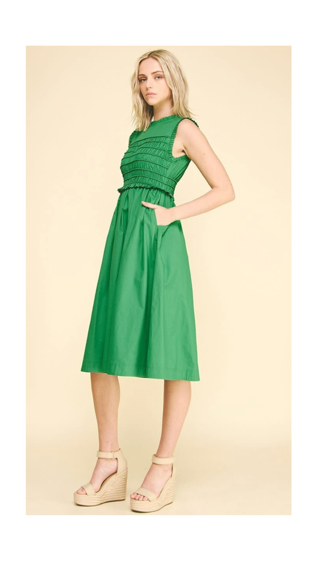 Woman wearing a green dress on a beige background