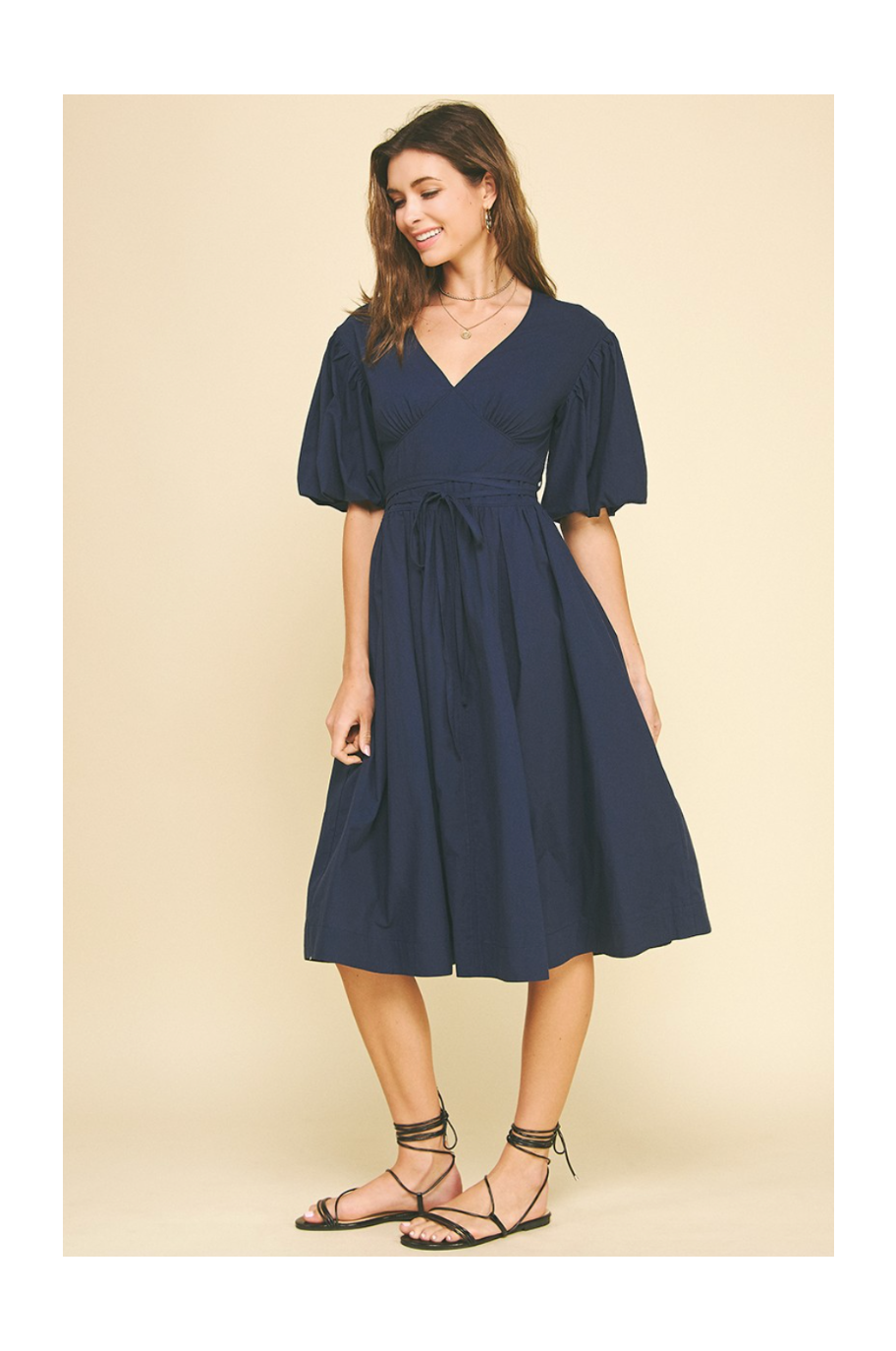 Woman wearing a navy blue dress on a beige background
