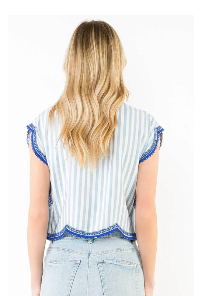 Woman wearing a striped sleeveless top and denim skirt on a white background