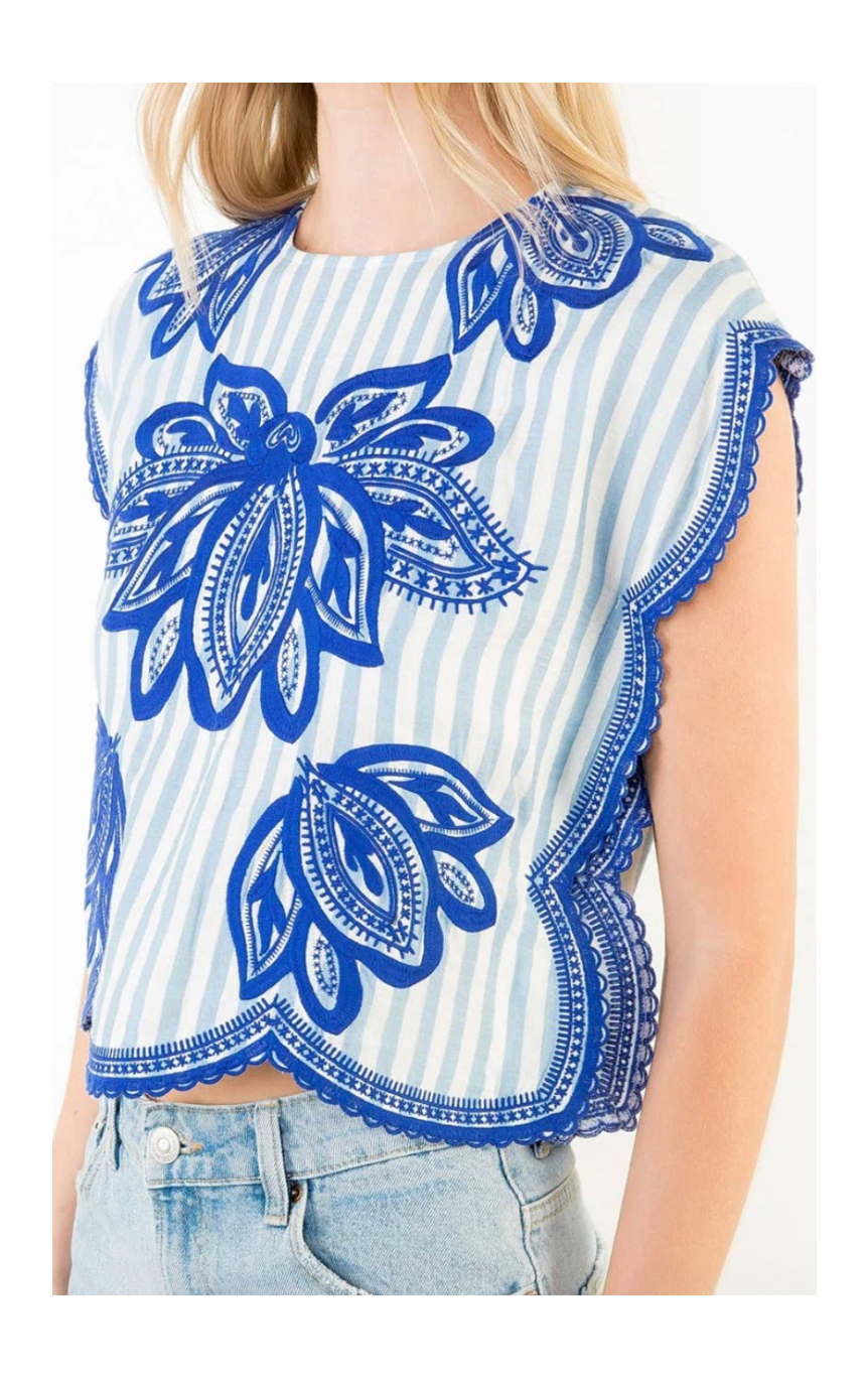 Blue and white patterned sleeveless top worn by a person