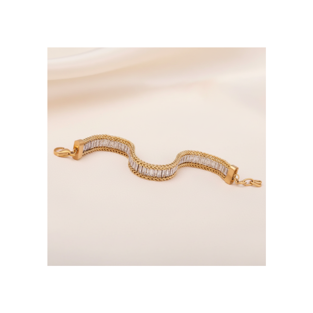 Gold bracelet with clear stones on a beige fabric background