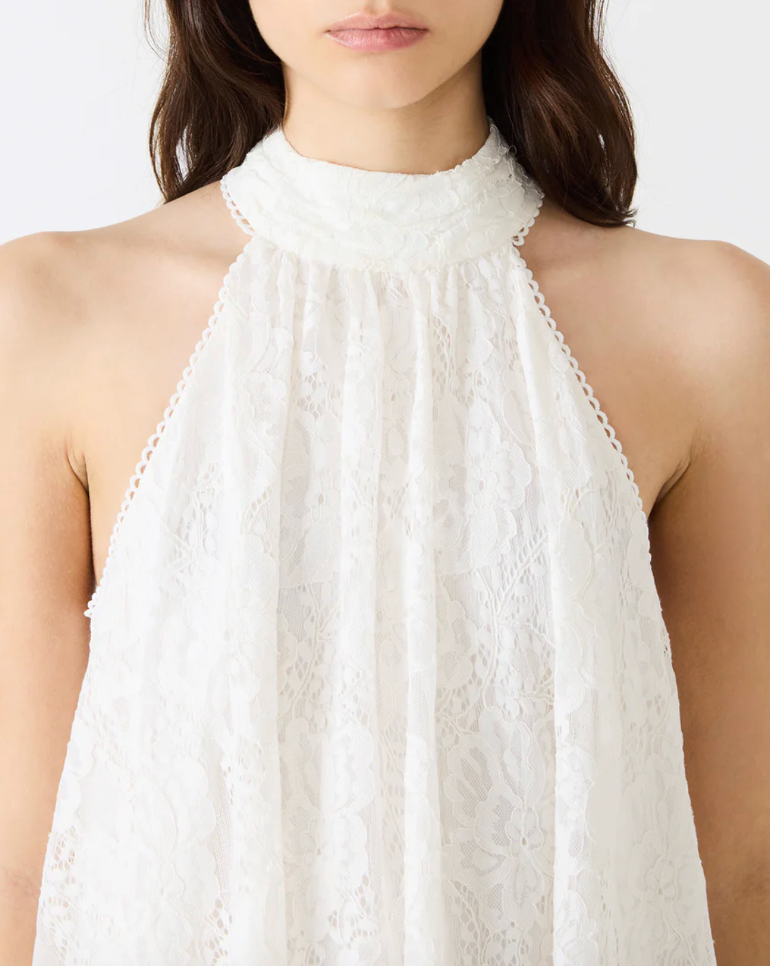 White lace halter top worn by a person on a white background