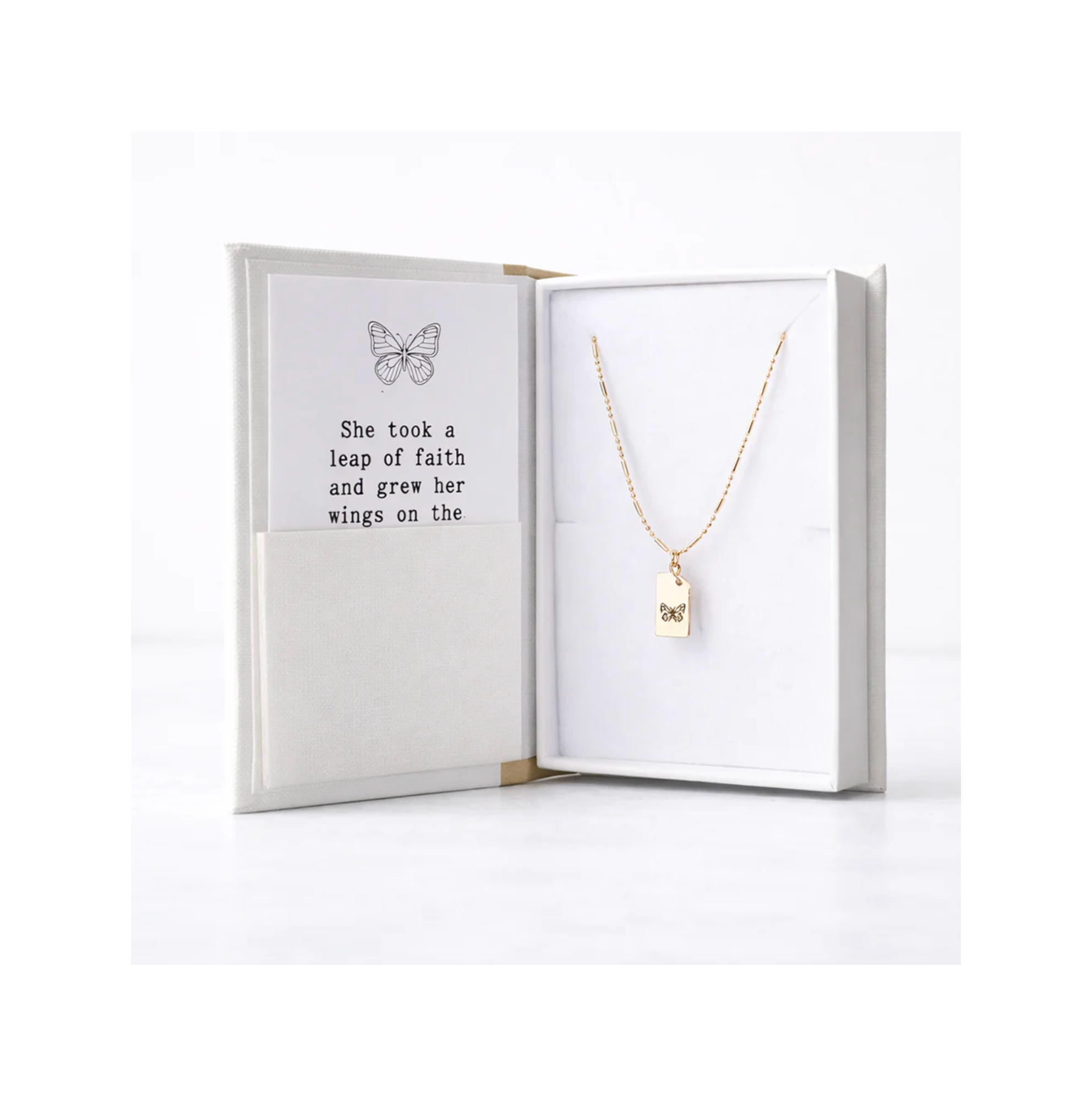 Gold necklace with a pendant in an open jewelry box on a white background