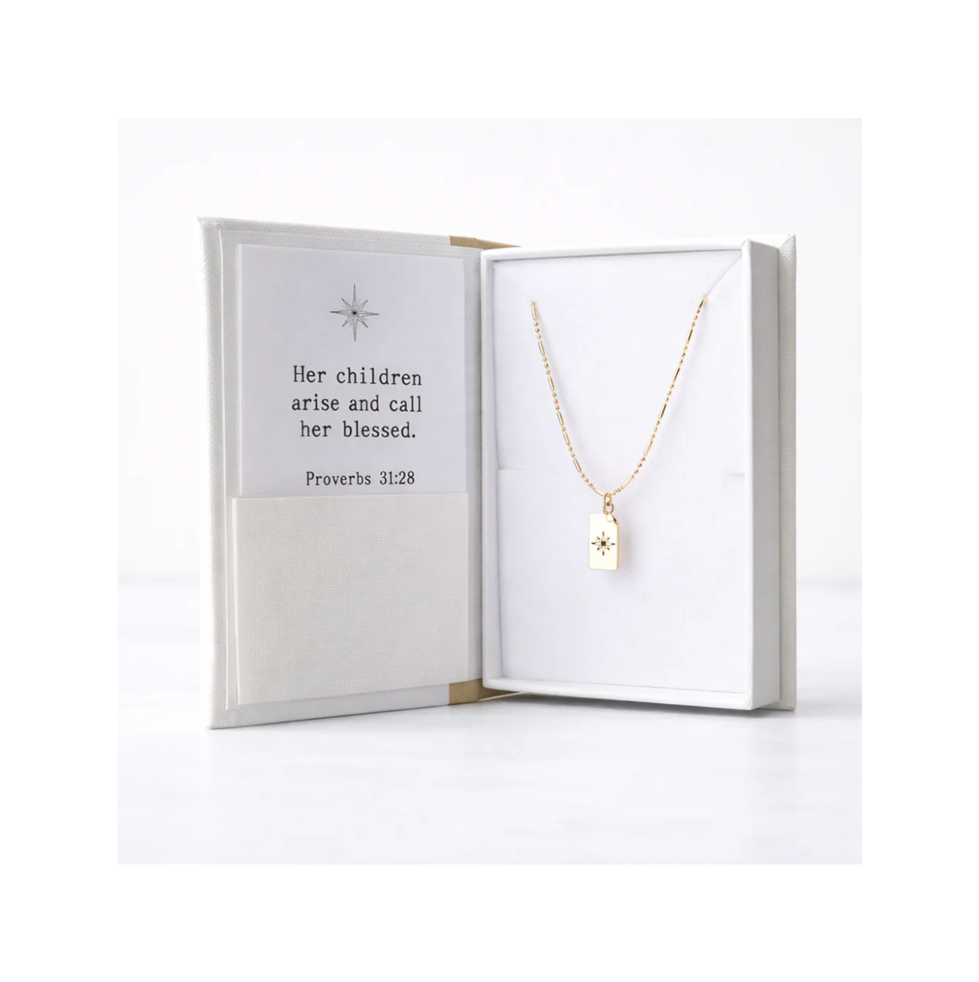 Gold necklace with a pendant in an open jewelry box on a white background