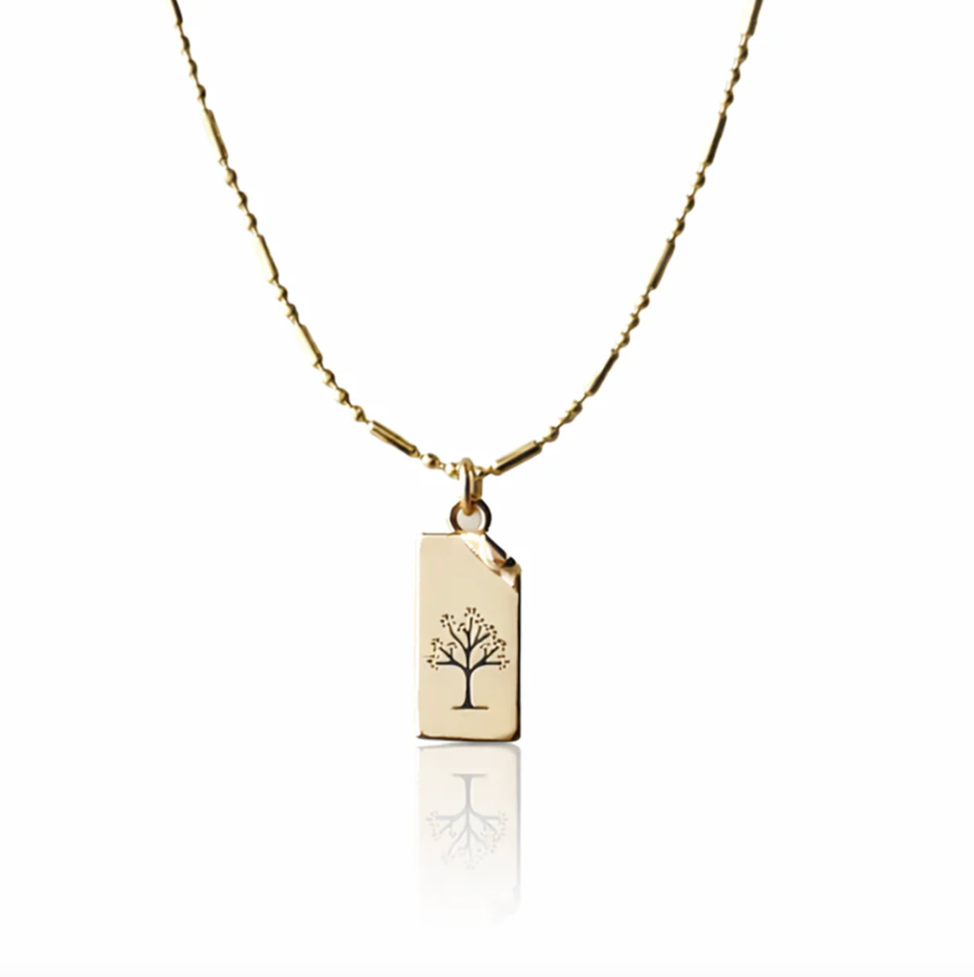 Gold necklace with a pendant featuring a tree design on a white background