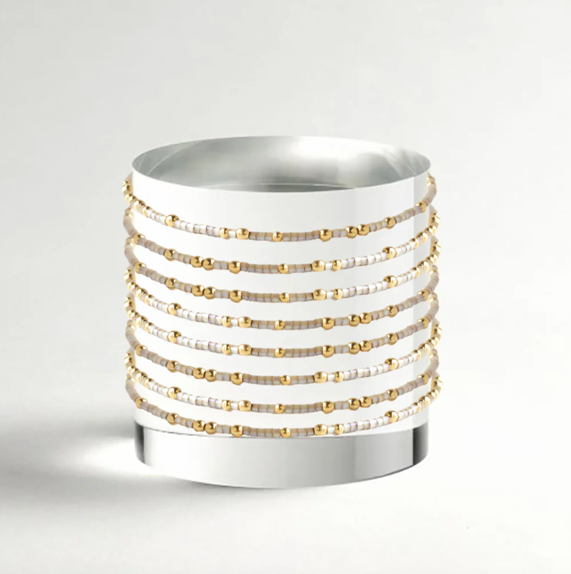 White ceramic planter with gold and silver bead accents on a light gray background