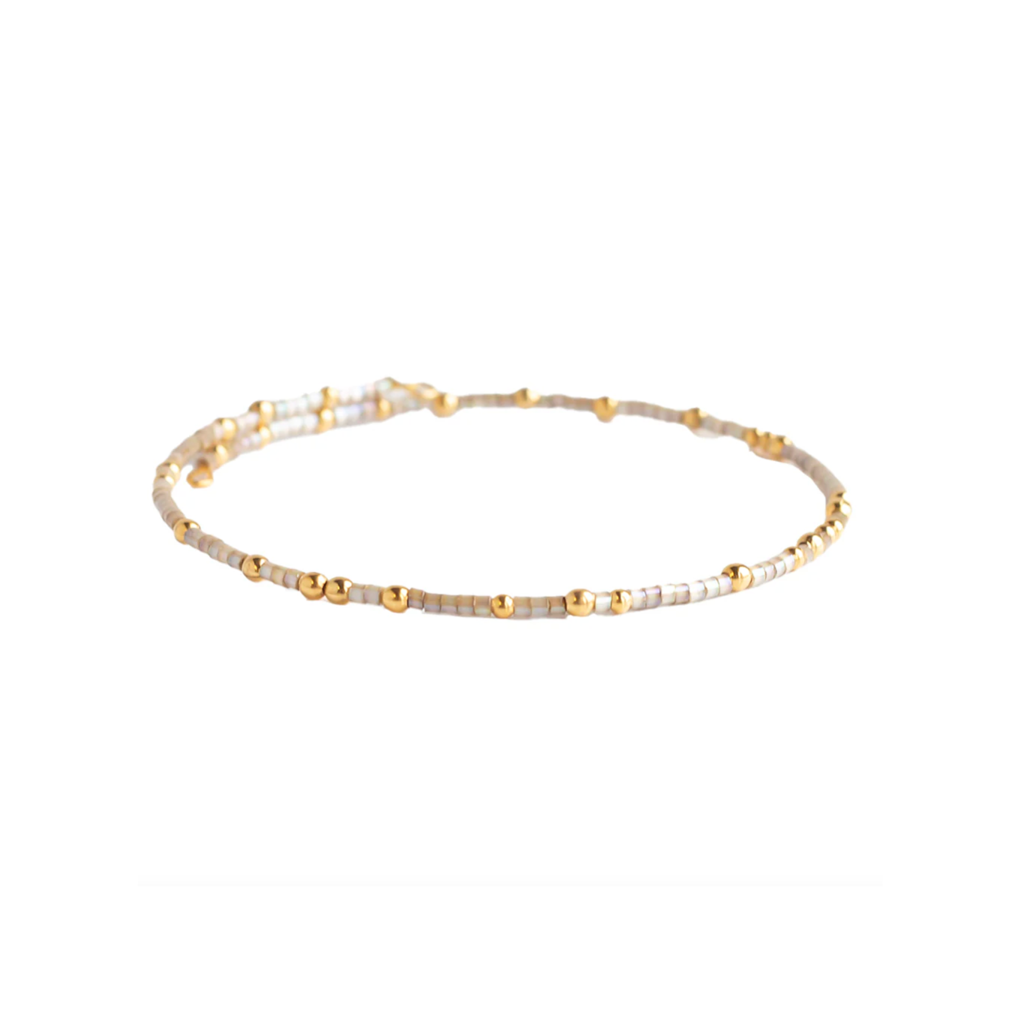 Beaded bracelet with gold and white beads on a white background