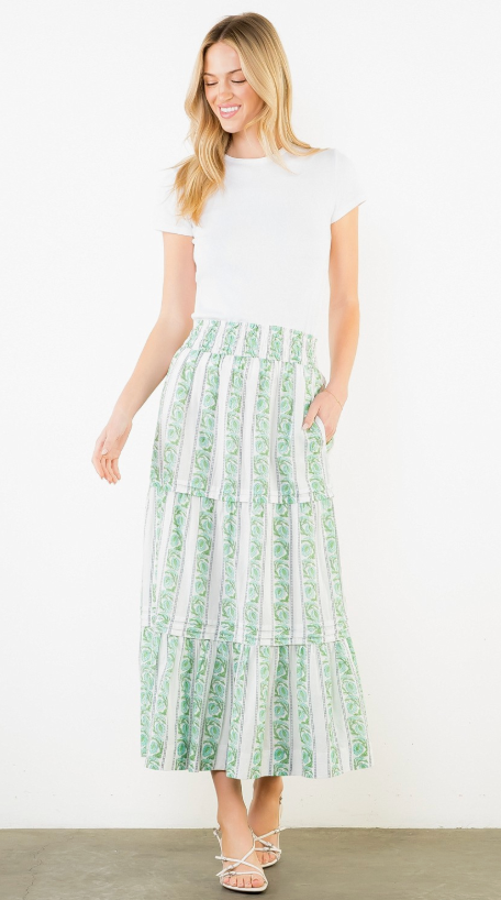 Woman wearing a white top and green patterned skirt on a white background