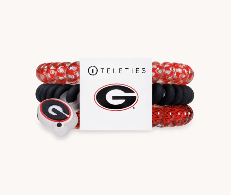 A set of three Georgia Bulldogs branded Teleties stretch bracelets, featuring red and black patterned, solid black, and white with red accents, displayed on a white card with the Georgia logo.